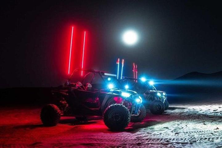Experience the Arabian Desert at night navigating rugged terrains in powerful 4x4 buggies under the moonlight with a memorable campfire snack break amidst stunning surroundings.